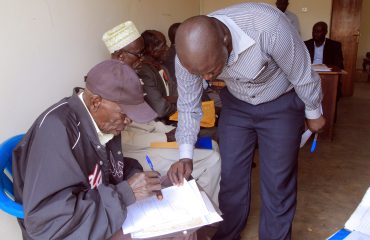 Yumbe district HRO assist pensioners while filling in the required form before validation is done